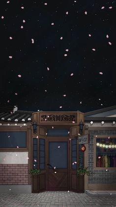 the entrance to a building with pink petals falling from it's windows at night