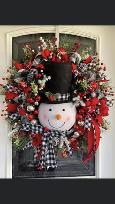 a christmas wreath with a snowman wearing a top hat