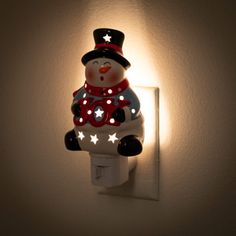 a light that is on the wall with a snowman figure in front of it