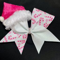 Pink Santa Hat Christmas Cheer Bow -rainbow white glitter bonded to white 3in ribbon -pink candy cane/peppermint swirl design on one side -pink Santa hat bonded to loop -AB rhinestone center **Santa hats are handmade and limited quantity. These sold out early last year so get them before they're gone Please note turn around time when ordering, if you need the bow by a certain date please contact me BEFORE ordering! All orders ship in a box to maintain the bows shape. Christmas Cheer Bows, Cheer Bows Diy, Cute Cheer Bows, Pink Santa Hat, Cheer Posters, Cheer Ideas, Cheerleading Bows, Cheer Coach, Cheerleading Gifts