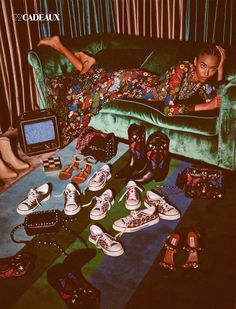 a woman laying on top of a green couch surrounded by shoes