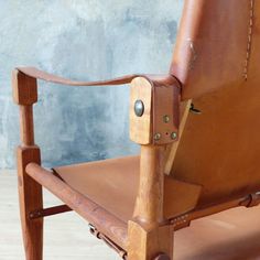 a brown leather chair sitting on top of a wooden floor