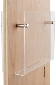 a wooden cabinet with clear glass door and metal handle on the bottom shelf, which is attached to a wood wall