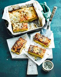 some food that is sitting in a pan on a table next to a knife and fork