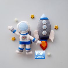 a stuffed toy is next to an outer space rocket on a white surface with stars