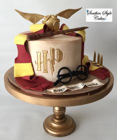 a harry potter themed birthday cake on a gold plate with scissors and other items around it