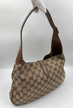 A stunning vintage Gucci Jackie bag made from the iconic GG beige canvas with brown leather trim and pale gold hardware. Inside the bag is lined with brown cotton lining and there is a zipped pocket for valuables. This bag is in good vintage condition with some slight wear to the base edges and leather parts. There is an ever so slight sticky feeling to the canvas - its only slight but need to mention. A true collectors item. Vintage Gucci Jackie, Pale Gold, Vuitton Bag, Exclusive Bag, Baby Bag, Handbag Backpack, Kids Bags, New Bag, Gucci Jackie Bag