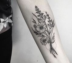 a black and white flower tattoo on the arm