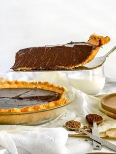 a piece of chocolate pie being lifted from a pie pan by a fork with the rest of the pie on it