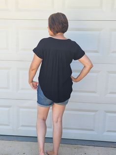 This color is EVERYTHING. It's a deep black and it's flowy! Jeans and your favorite pair of booties would look beautiful! If you are looking for a laid back summer vibe, pair it with these distressed shorts! This top includes a split round neckline, short sleeves, shirred shoulders, functional front buttons, and back yoke. Also available in Olive Green. ABOUT THIS ITEM: Made in Indonesia. Fabric is 100% Rayon. Turn inside out and hand wash in cold water. The model is 5'6, and wearing a medium. Flowy Jeans, Look Beautiful, Distressed Shorts, Woven Top, Deep Black, Summer Vibes, Round Neckline, Olive Green, Cold Water