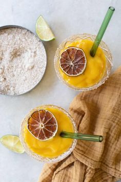 two glasses filled with orange juice and garnished with sliced grapefruits