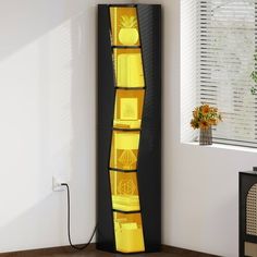 a tall black and yellow display case in the corner of a room with a window