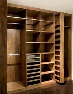 an empty wooden closet with many shelves and drawers in it's center, along with wood flooring