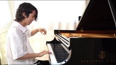 a young man is playing the piano in his home