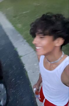 a man in white shirt and red shorts walking down street