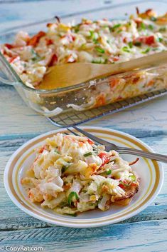 a casserole dish with chicken and vegetables in it on a plate next to a serving spoon