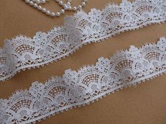 two white lace garters with pearls on them