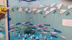 paper airplanes are flying in the air on display