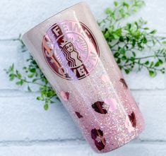 a pink starbucks cup sitting on top of a white brick wall