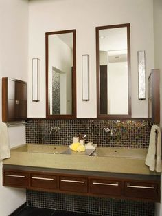 a bathroom sink with two mirrors above it