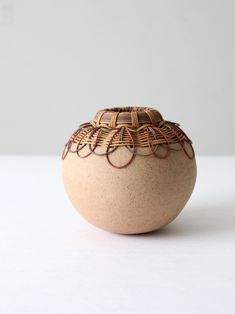 a brown and white vase sitting on top of a table