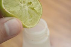 a person holding a lime in their hand