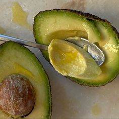 an avocado cut in half with a spoon