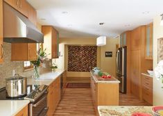 a kitchen with wooden cabinets and stainless steel appliances, along with an island in the middle