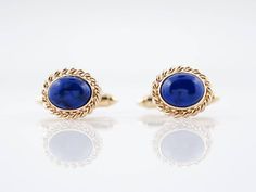 Modern Cufflinks Cabochon Cut Lapis in 18k Yellow Gold$2,550.00These Modern cufflinks are made with lapis lazuli and 18k yellow gold. The lapis pieces are smooth, oval cabochons that are bordered by a frame of twisted gold wire. The buttery yellow gold provides a striking contrast to the vibrant blue of the gemstones.Composition: 18 Karat Yellow Gold, 14 Karat Yellow GoldINV: 4061 Primary Stone: Natural Lapis LazuliShape and Measurements: 7.5 mm x 3.5 mm (10)General Characteristics: Height Above Formal Lapis Lazuli Jewelry, Antique Wedding Bands, Lapis Lazuli Jewelry, Metal Shop, Shop Engagement Rings, Gold Wire, Vibrant Blue, Oval Cabochon, Shop Necklaces