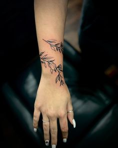 a woman's hand with a flower tattoo on it