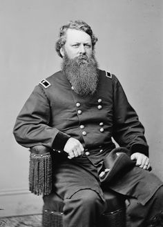 an old black and white photo of a man with a long beard sitting in a chair