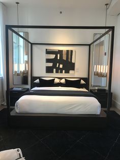 a bedroom with a four poster bed and mirrors on the wall