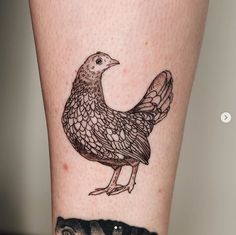 a tattoo on the leg of a woman with a bird on it's leg