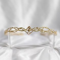 King's Crown features a beautiful gold colored metal braid formed into a circle highlighted by a gold color crystal at the center of the forehead. King's crown is tapered to fit just right and add the perfect touch.  Circumference: 6.5 Inches Height of Center: 1.25 Inches Ring Height: 0.25 Inches Crown is a disconnected circle and is adjustable to fit most hair styles and head shapes.  All items ship from Michigan, USA. WARNING: CHOKING HAZARD This item is not intended for use by children under the age of 5 years old.  There are small pieces that could fall off and create a choking hazard.  All use of this product by any minor, child or dependent should be supervised by an adult 18 years of age or older. Bridal Tiara Gold, Gold Wreath Crown, Princess Alessandra, Elf Oc, Queen Crowns, Gold Crowns, King's Crown, Wedding Hair Wreath, Gold Tiara