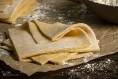 floured tortilla wraps on top of parchment paper next to a bowl of flour