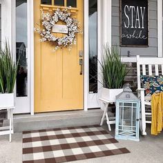 a yellow door and some chairs on the front porch