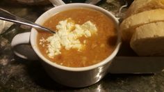 a bowl of soup with bread on the side