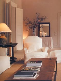 a living room filled with furniture and a mirror on the wall above it's door