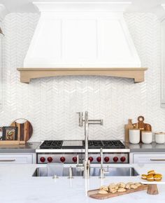 a kitchen with white counter tops and stainless steel appliances in front of a range hood