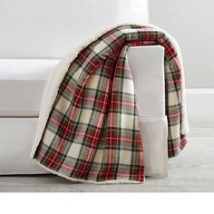 a plaid blanket is draped over the back of a couch