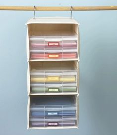 an organized closet with drawers and labels on the bottom shelf, hanging from a clothes line