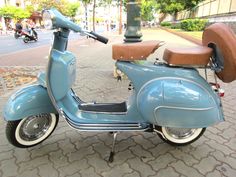 a blue scooter is parked on the sidewalk