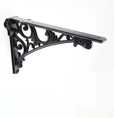 an ornate black shelf bracket on a white wall