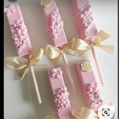 pink and gold candy sticks with bows on them