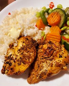 a white plate topped with chicken, rice and veggies