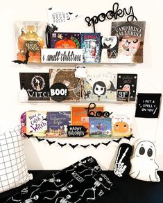 a bed with halloween decorations and books on the shelves above it is decorated for halloween