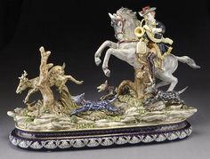 a figurine of a man riding on a horse with other figures around him