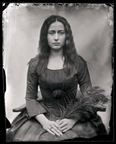 an old black and white photo of a woman with long hair