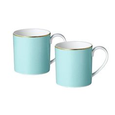 two teal mugs with gold rims on each one and the other side