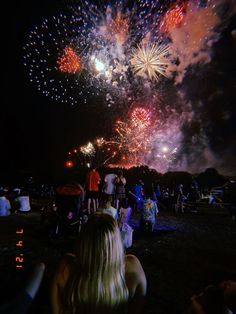 people are watching fireworks in the dark sky